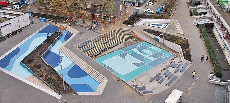 Waterplein in Rotterdam met blauwe waterbassins en sportvelden