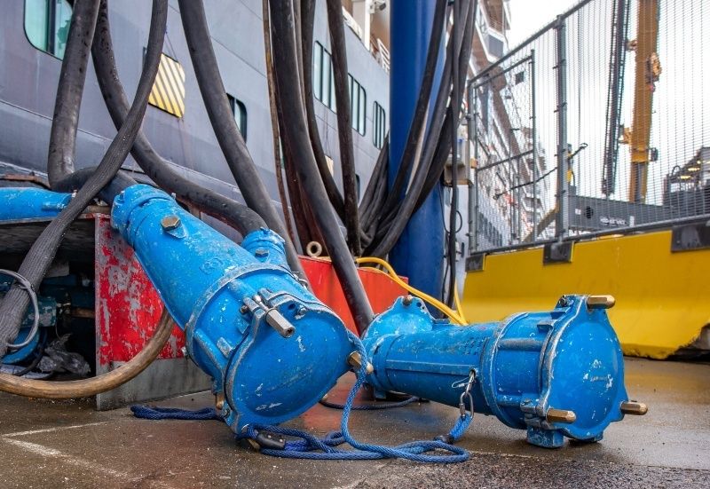 Blauwe walstroomkabels en aansluitingen op een kade in de haven
